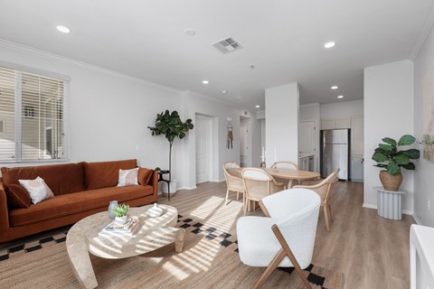a living room with white walls and a brown couch